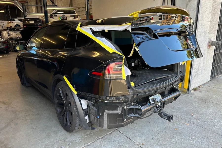 Black Tesla Model Y with rear collision damage mid-repair at EV Central Service EV body shop near San Rafael Marin County