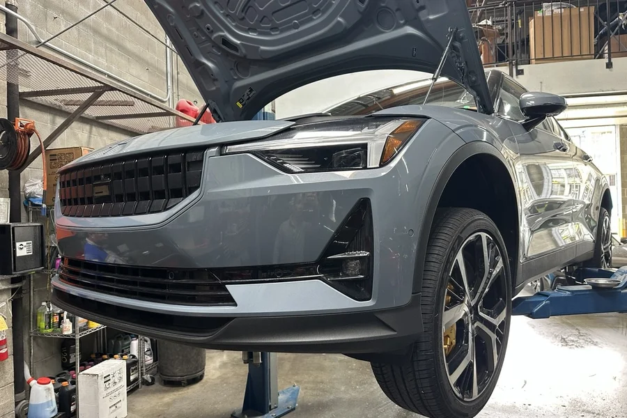 Grey Polestar 2 on lift with hood open for EV collision repair at EV Central Service near Noe Valley Castro San Francisco