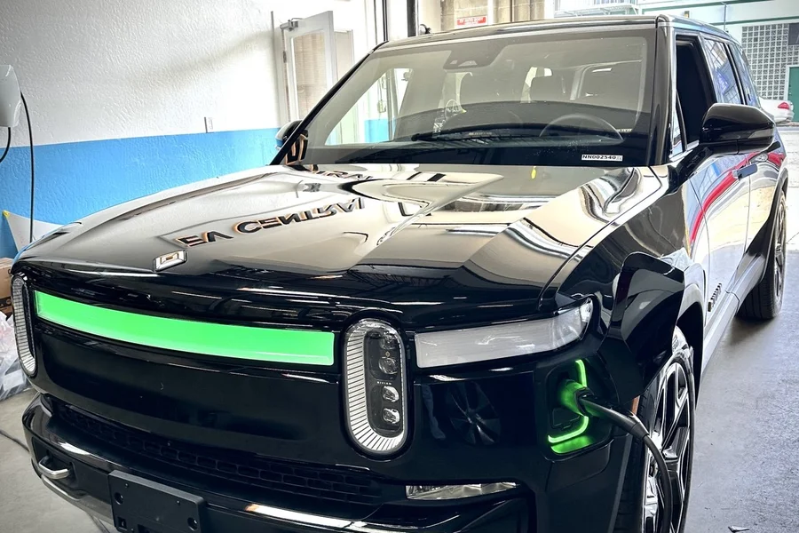 Black Rivian R1S with green light bar charging at EV Central Service EV repair shop near Potrero Hill Dogpatch San Francisco