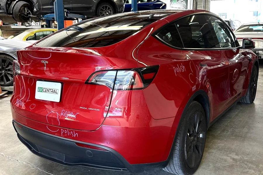 Red Tesla Model Y marked for collision repair and polish at EV Central Service shop near Palo Alto and Mountain View