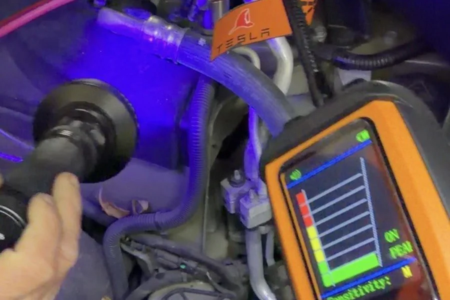 Technician using UV refrigerant leak detector in Tesla frunk at EV Central Service mechanical service near Marin County
