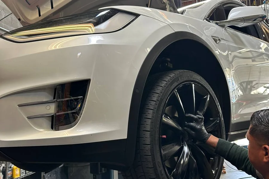 Tesla Model X front wheel inspection on lift for highway vibration diagnosis EV Central SF