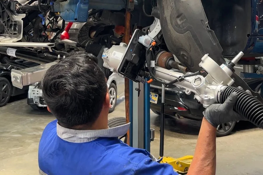Mechanic replacing Tesla electric steering rack assembly on lift at EV Central Service San Francisco